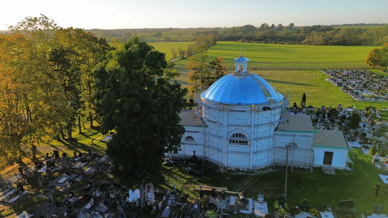 Gerai matyti apvalioji pastato dalis, šoniniai priestatai ir remonto pastoliai.